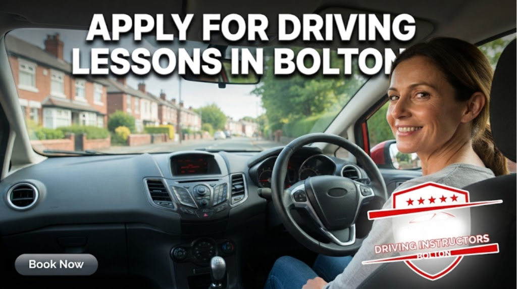 A friendly female driving instructor smiles at the camera from the passenger seat of a right-hand drive car, with the dashboard, steering wheel, and a view of a residential street in Bolton visible through the windshield.